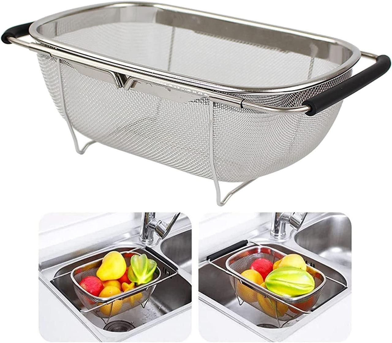 Stainless steel colander with a handle over a kitchen sink filled with fruits.