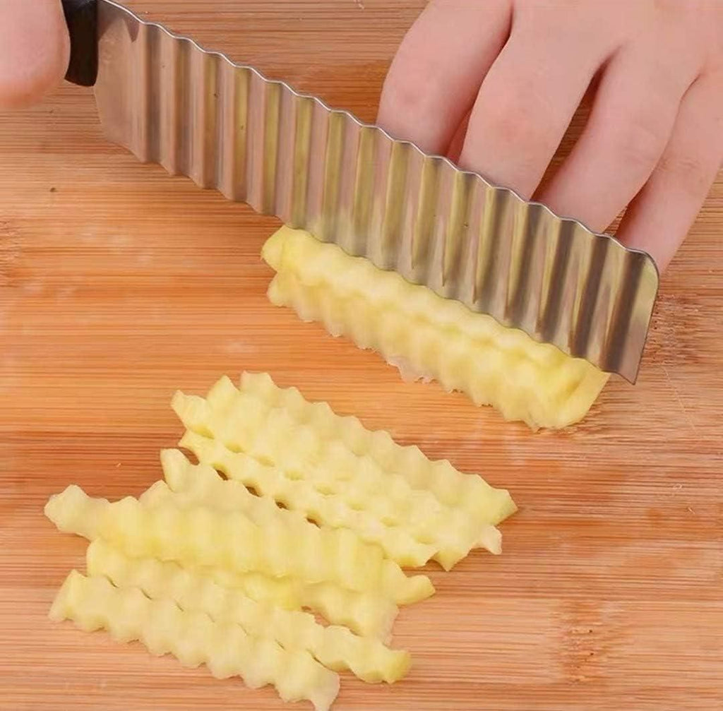 Waffle knife being used to cut potatoes on a wooden surface
