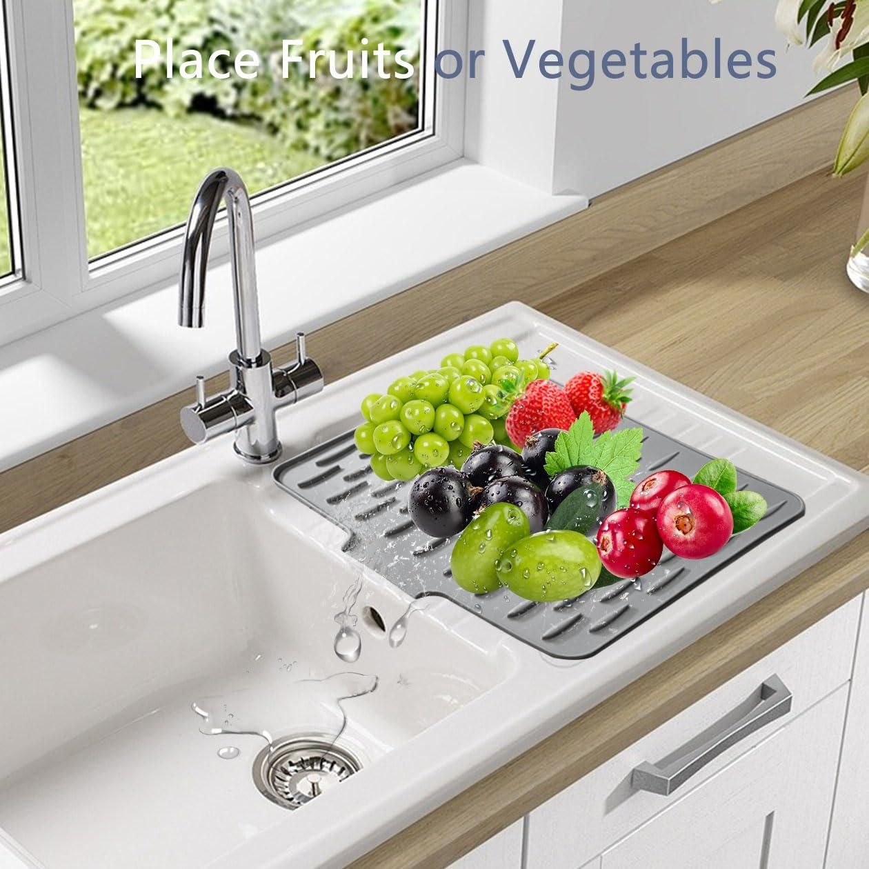 Fruit and vegetable drying mat on a kitchen sink with fruits and vegetables on it.